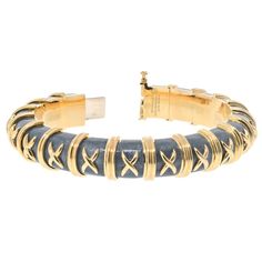 Introducing the exquisite 18K Schlumberger Croisillon Bracelet, a true testament to the iconic style and artistry of Jean Schlumberger. This captivating bracelet is crafted in 18K gold and features a mesmerizing design that exudes elegance and sophistication. The centerpiece of the bracelet is the intricate croisillon pattern, meticulously created with asphalt grey enamel. The juxtaposition of the rich enamel against the lustrous gold creates a striking contrast that adds depth and dimension to Designer Engraved Yellow Gold Bracelet, Yellow Gold Intaglio Bracelet For Formal Occasions, Elegant Yellow Gold Bracelet With Intaglio, Elegant Yellow Gold Intaglio Bracelets, Elegant Yellow Gold Intaglio Bracelet, Elegant Yellow Gold Bracelets With Intaglio, Elegant Gold Intaglio Bracelet, Formal Yellow Gold Intaglio Bracelets, Formal Yellow Gold Intaglio Bracelet