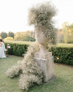 an outdoor ceremony with a sculpture and flowers