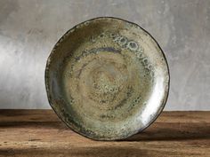 a brown plate sitting on top of a wooden table