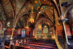 the interior of an old church with stained glass windows and chandeliers hanging from the ceiling