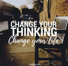 a bench sitting next to a brick wall with the words change your thinking change your life