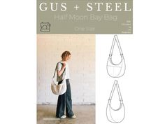 a woman carrying a white bag with the text gus + steel half moon baby bag