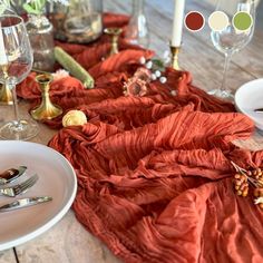 the table is set with silverware, wine glasses, and red cloths on it