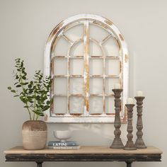 a table topped with vases and candles next to an old fashioned window pane