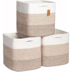 three white and beige baskets stacked on top of each other, one with a brown tag