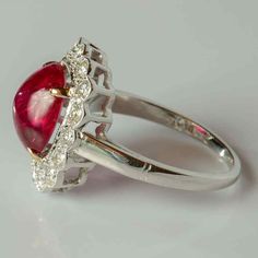 a close up of a ring with a red and white stone in it's center