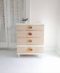 a white dresser with three drawers in a room