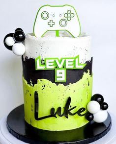 a cake that is decorated to look like a video game controller with black and white balls around it