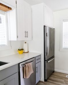 a kitchen with white cabinets and stainless steel appliances, including a dishwasher in the center