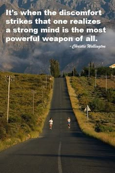 two bicyclists are riding down the road in front of mountains with a quote on it