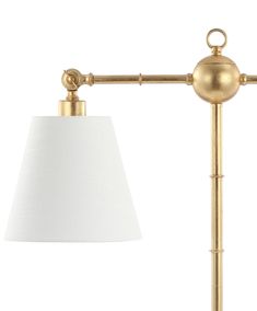 a gold lamp with a white shade on the side and a light bulb attached to it