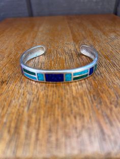 Beautiful Sterling Silver Turquoise and Lapis lazuli Inlaid Cuff Bracelet measuring approx 6 3/4" interior circumference including the gap of 1 3/8" and 3/8" wide, marked CCO925 Adjustable Southwestern Blue Cuff Bracelet, Southwestern Style Blue Bangle Bracelets, Southwestern Blue Cuff Bracelet As Gift, Southwestern Style Blue Bangle Bracelet, Multicolor Inlay Cuff Bangle Bracelet, Multicolor Inlay Bangle Cuff Bracelet, Adjustable Blue Cuff Bracelet With Inlay, Adjustable Blue Inlay Cuff Bracelet, Bohemian Blue Bracelets With Inlay