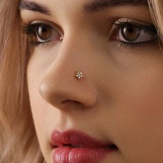 a close up of a woman with a nose piercing on her forehead and eyeliner