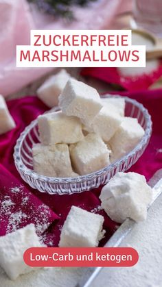 a bowl filled with marshmallows on top of a red cloth next to a knife