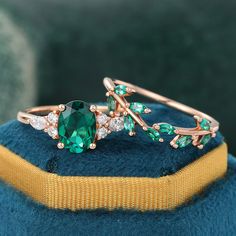 a close up of a ring with green stones and leaves on it's side