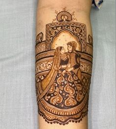 a woman's arm with a henna tattoo on it and an image of a bride and groom