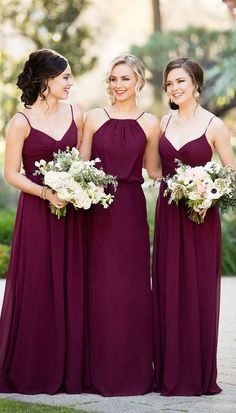 three bridesmaids in purple dresses are standing together and smiling at each other with their bouquets