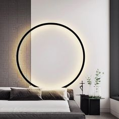 a modern bedroom with a circular light on the wall and bed in front of it