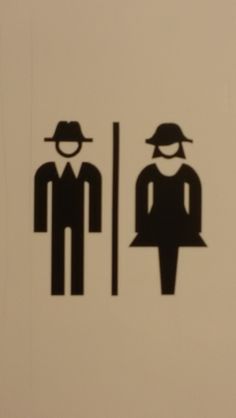 the bathroom door is decorated with black and white silhouettes of two men in hats