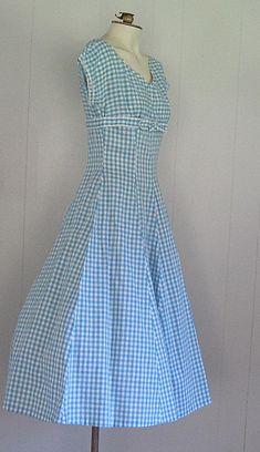 DESCRIPTION 1950s cotton dress Blue and white gingham Wide v-neck embellished with rhinestones and beads Under bust bow Fitted bodice/waist and full skirt Hand made Narrow white rick rack trim APPROXIMATE MEASUREMENTS (INCHES): Bust: 33 Waist: 26 Hip: OPEN Bodice (shoulder to waist): 15 Skirt (waist to hem): 30 CONDITION Excellent/very good. The under arms on both sleeves have been repaired/reinforced. Aside from this, the dress appears unworn. 1960s Clothing, 60s Clothing, Summer Dress Blue, Dress With Rhinestones, 1960s Dresses, 1950’s Style, 1960s Outfits, Blue And White Gingham, Blue Summer Dresses