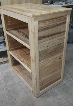 a wooden cabinet sitting on top of a tile floor next to a counter with drawers