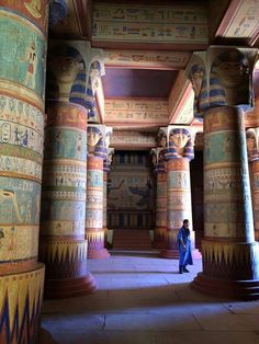 an egyptian style building with columns and paintings on the walls