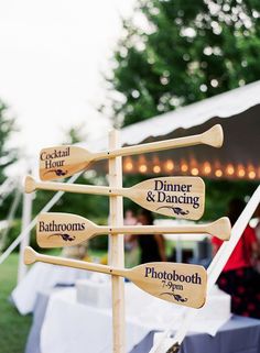 wooden paddle signs are on display at an outdoor event