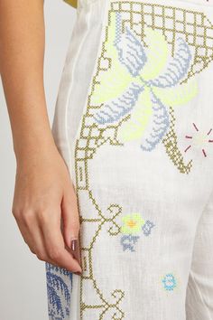 a close up of a woman's pants with flowers on it and an embroidered design