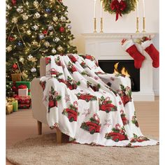 a living room with a christmas tree and stockings on the fire place in front of it