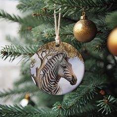 a christmas ornament with a zebra on it's side hanging from a tree