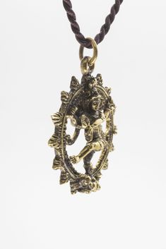 Size: ≈ 1.2"x 1.2"x 0.2" Material:Brass -- Shiva Nataraja Pendant Lord Shiva as the cosmic dancer or Nataraja. Shiva's dance is the dance of creation and destruction. Handcrafted with care in Thailand Size: ≈ 1.2"x 1.2"x 0.2" inches Material: Brass comes with a ≈ 24" inch brown fabric necklace Spiritual Adjustable Jewelry For Navratri, Adjustable Spiritual Jewelry For Navratri, Adjustable Spiritual Jewelry For Festivals, Symbolic Intricate Design Jewelry For Festivals, Symbolic Ceremonial Jewelry For Festivals, Symbolic Jewelry For Navratri Puja, Symbolic Jewelry For Puja And Festivals, Symbolic Jewelry For Puja And Navratri, Symbolic Jewelry For Rituals And Festivals