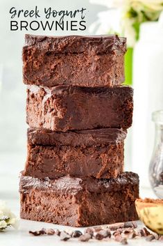 four brownies stacked on top of each other with coffee beans around them and the words greek yogurt brownies