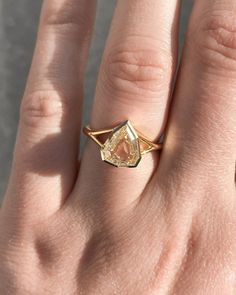 a woman's hand with a yellow diamond ring on top of her left hand