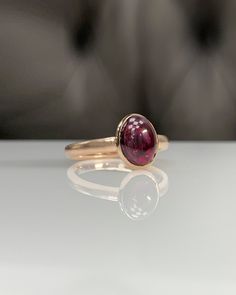 Natural Rhodolite Garnet Ring * Dainty Cabachon Ring * Genuine Garnet & 14K Solid Gold * Best Gift for Her/Him * Handmade Ring ◎ Details ◎ ○ Gemstone Details .Natural RHODOLITE GARNET Oval Cut 9X7 mm approx. 2.11 ct ○ Gold Details 14K Solid Gold Width of Band : 2.50 mm Weight of Ring : approx 3.80 gr Made to Order HANDMADE ITEM ○ Upgrade to Solid 18K Gold, please click the link below: https://www.etsy.com/listing/962826004 For more CABACHON BEZEL rings : http://etsy.me/37fvI60 All of our jew Elegant Domed Jewelry With Bezel Setting, Classic 14k Gold Sapphire Oval Cabochon Ring, Luxury 14k Gold Oval Cabochon Rings, Elegant Amethyst Bezel Set Oval Cabochon Ring, Elegant Amethyst Oval Cabochon Ring With Bezel Setting, 14k Gold Rings With Bezel Set Oval Cabochon, 14k Gold Rings With Bezel Setting And Oval Cabochon, Luxury 14k Gold Ruby Cabochon Ring, Elegant 14k Gold Rings With Oval Cabochon