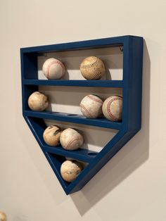 baseballs are lined up in the shape of a triangle on a wall mounted shelf