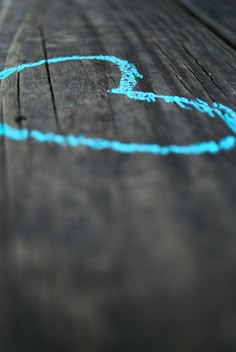 a close up of a wooden table with blue chalk writing on the top and bottom