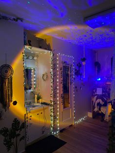 a room that has lights on the walls and some plants in the corner, along with other decorations