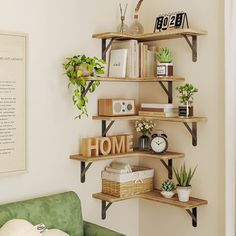 a living room with a green couch and shelves filled with books, plants and other items