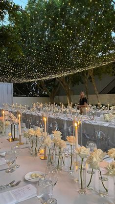 the tables are set up with clear vases and candles for an elegant wedding reception