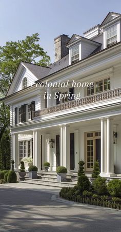 a large white house with the words colonial home in spring