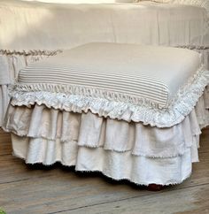 a white bed sitting on top of a wooden floor