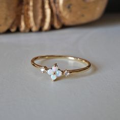 This dainty Forget Me Not ring features four natural Australian opal hugged between two natural diamonds. Set on a polished dainty band. A beautiful ring to wear on your finger to remind you of the beauty of life. Crafted in 14K solid gold in our NYC studio. 14K solid gold Natural Australian opals and diamonds 1.2mm ring band ** This item is specially made for you. Please allow 1-2 week lead time. Shipping:Domestic: Free standard shipping within the U.S.International: Free standard shipping for Delicate 14k Gold Opal Ring, Delicate Yellow Gold Opal Ring, Opal And Sapphire Ring, Forget Me Not Flower, The Beauty Of Life, Dainty Band, Nyc Studio, Beauty Of Life, Birthday Wishlist