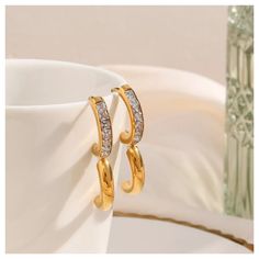 These gorgeous 14K Gold Huggie Hoop Earrings are 20mm, 14K gold plated with stainless steel and high quality cubic zirconia. The 14K Gold Huggie Hoop Earrings make the perfect gift for birthdays, Christmas Gifts, formal attire, business or casual. These earrings are also tarnish free, water proof and hypoallergenic. Order your 14K Gold Huggie Hoop Earrings now with our FREE & fast same day shipping! Trendy Yellow Gold Hoop Earrings For Anniversary, Trendy Cubic Zirconia Hoop Earrings For Gift, Gold Cubic Zirconia Hoop Earrings Gift, Plated Hoop Drop Earrings For Anniversary, Modern Gold Cubic Zirconia Huggie Earrings, Modern Gold Huggie Earrings With Cubic Zirconia, Cubic Zirconia Hoop Earrings As Gift, Gold Hoop Earrings With Diamond Accents For Everyday, Gold Hoop Earrings With Diamond Accents As Gift