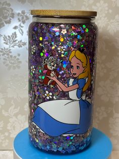 there is a jar with an image of alice and the owl in it on top of a blue stand