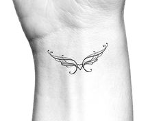 a black and white photo of a wing tattoo on the left side of a woman's arm