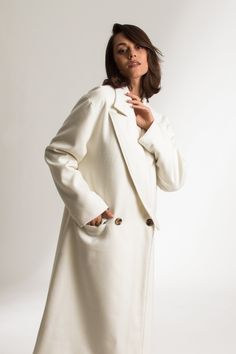 The Jenny Coat is a relaxed fit, double-breasted coat. Crafted from a virgin wool blend, which creates a structured, tailored look and feel. This full-length coat has oversized lapels and features two flap pockets. This sustainable coat is tailor made and on demand. It takes us 12 hours to make this coat. PLEASE ALLOW 1-3 BUSINESS DAYS FOR PRODUCTION Classic Structured Double-breasted Wool Coat, Modern Single-breasted Structured Wool Coat, Luxury Classic White Wool Coat, Elegant Beige Double-breasted Wool Coat, Elegant Double-breasted Cream Wool Coat, Full Length Coat, Oxblood Red, Winter Trench Coat, Cool Face