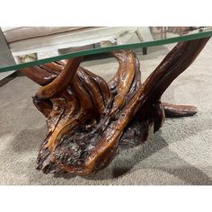 a glass top coffee table with wooden branches on it