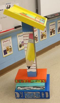 a stack of books sitting on top of each other in front of a whiteboard