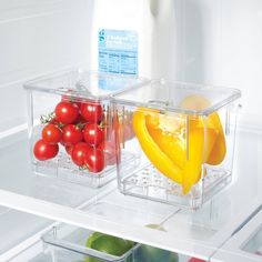 two plastic containers filled with different types of fruits and vegetables sitting on top of an open refrigerator door