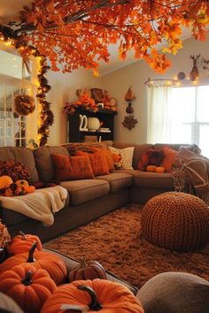 a living room filled with lots of furniture covered in fall leaves and pumpkins on the floor